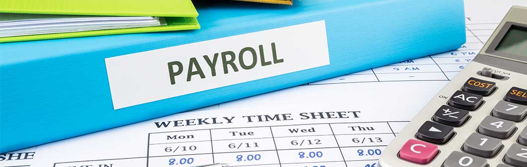 Binder labeled 'Payroll' placed next to a calculator, symbolizing payroll management and tax calculation for business entities.