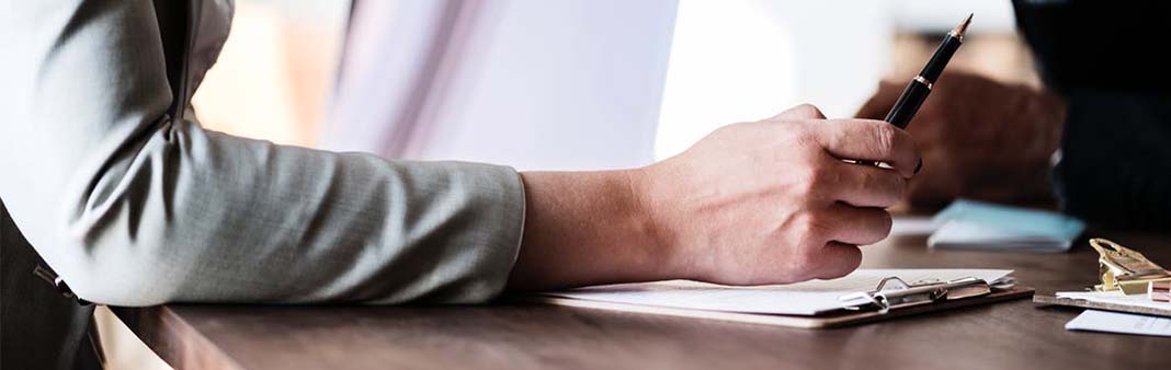 Person calculating financial data on a tablet to protect their bank account from potential garnishment.