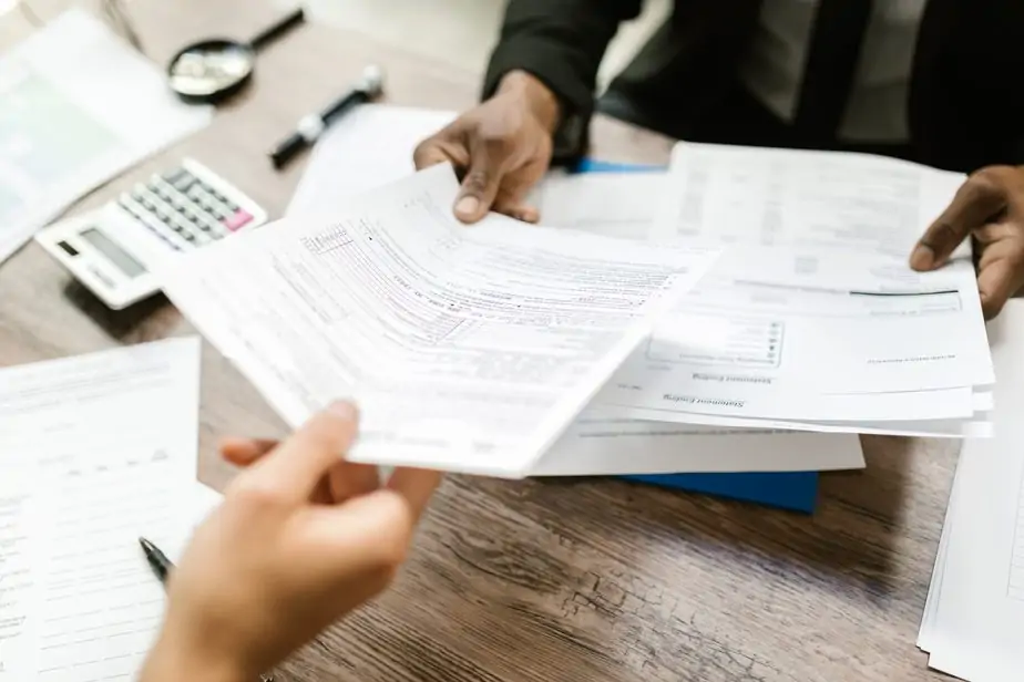 Workers conversing over legal paperwork, with a focus on registered agent services.